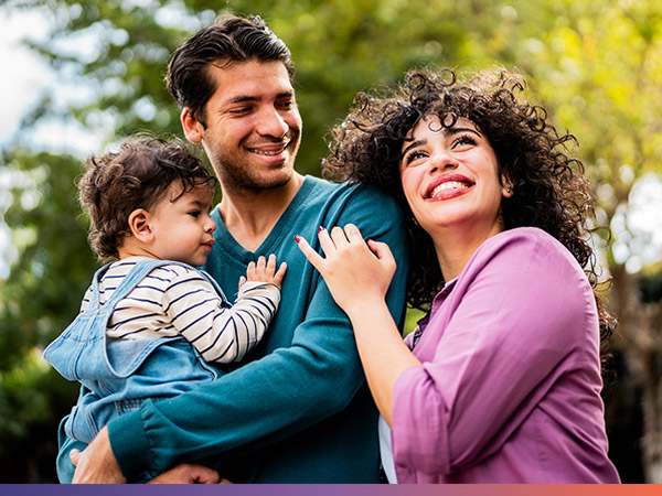 family smiling and holding child