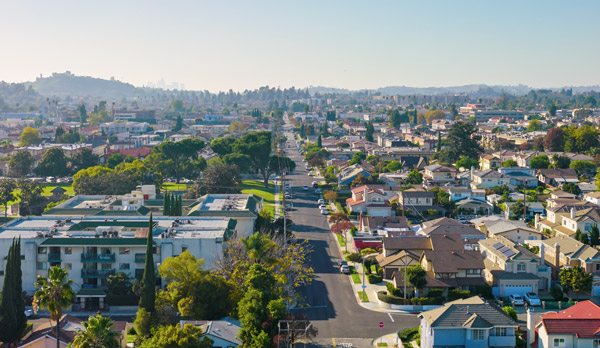 Aerial view of a Southern California residential neighborhood with homes, apartment buildings, and tree-lined streets.